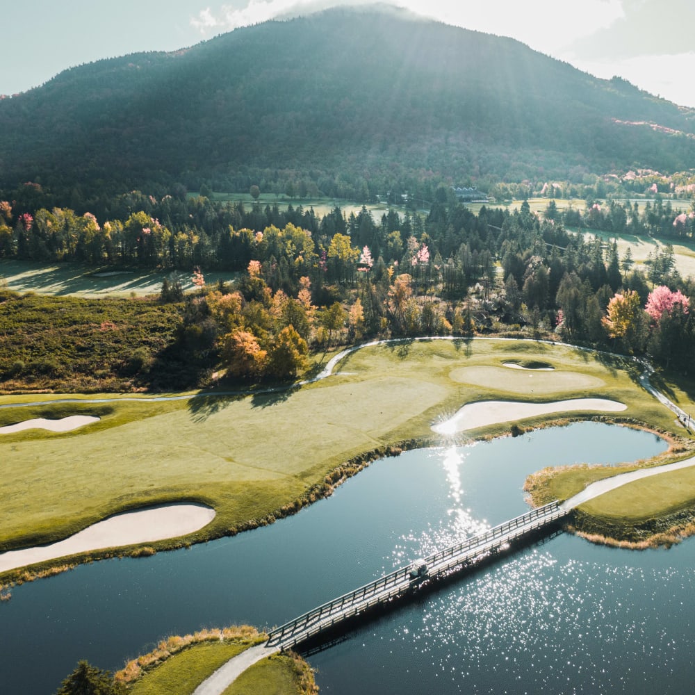 Vue aérienne d'un terrain de golf avec une montagne en arrière-plan.