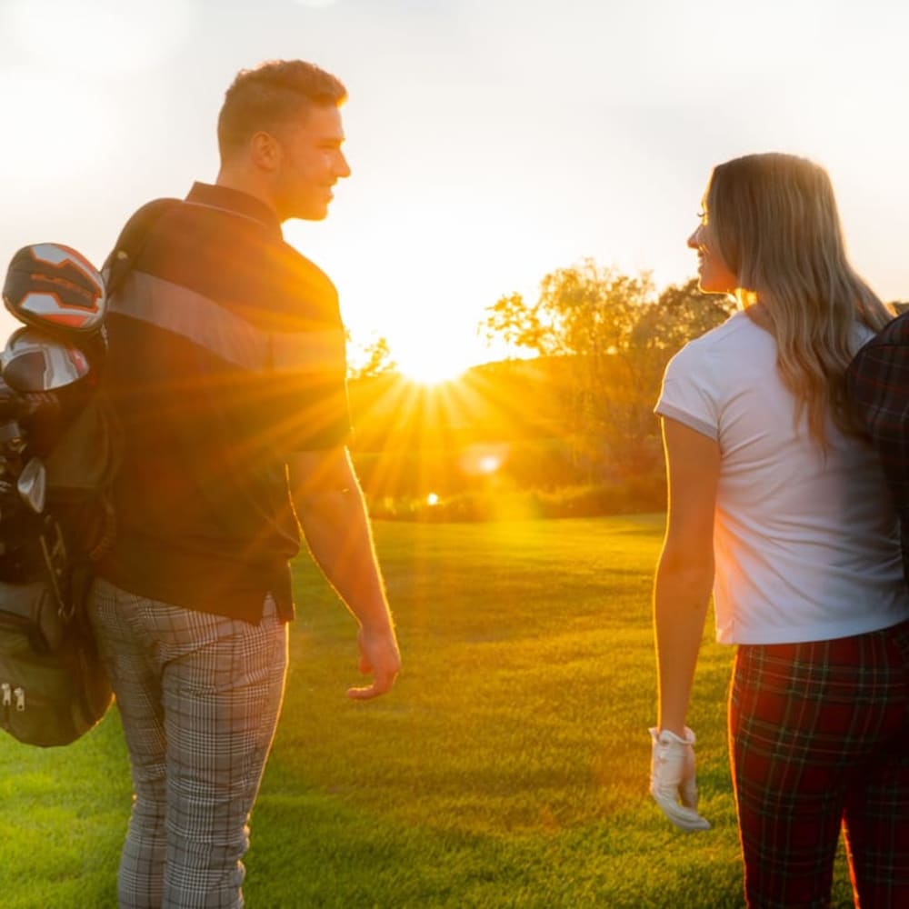 A couple of golfers at sunset.