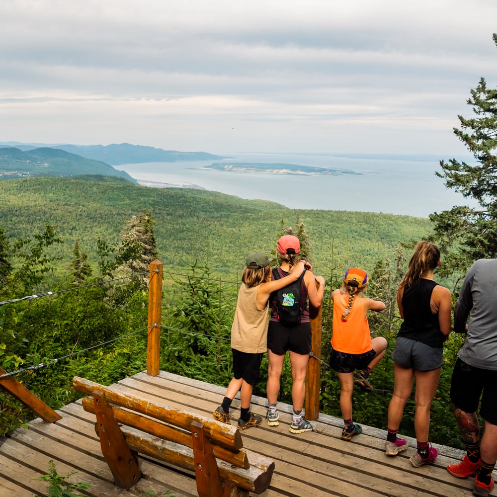 Family on a hike stopping at a lookout in Charlevoix.