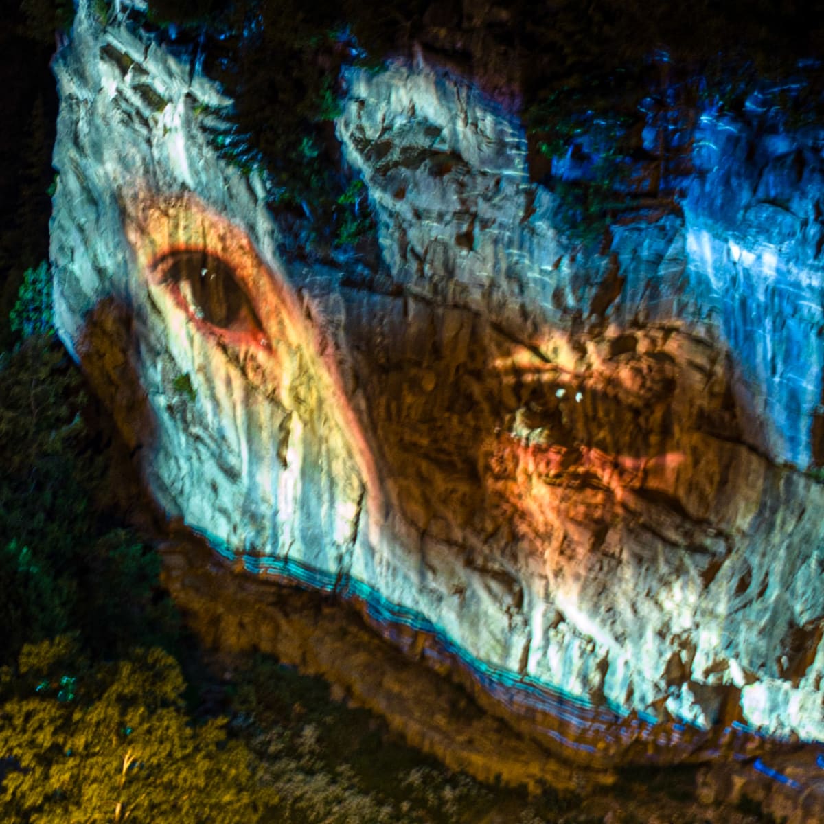 Cité Mémoire - Projection lumineuse d'un regard humain sur une paroi rocheuse la nuit