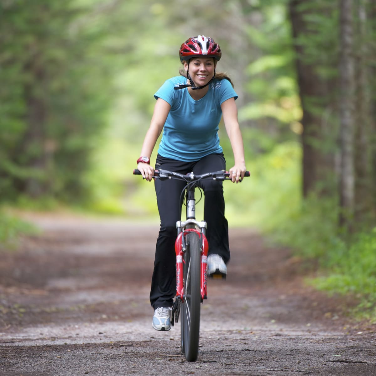 Femme à vélo sur une piste en forêt - Parc de la Mauricie