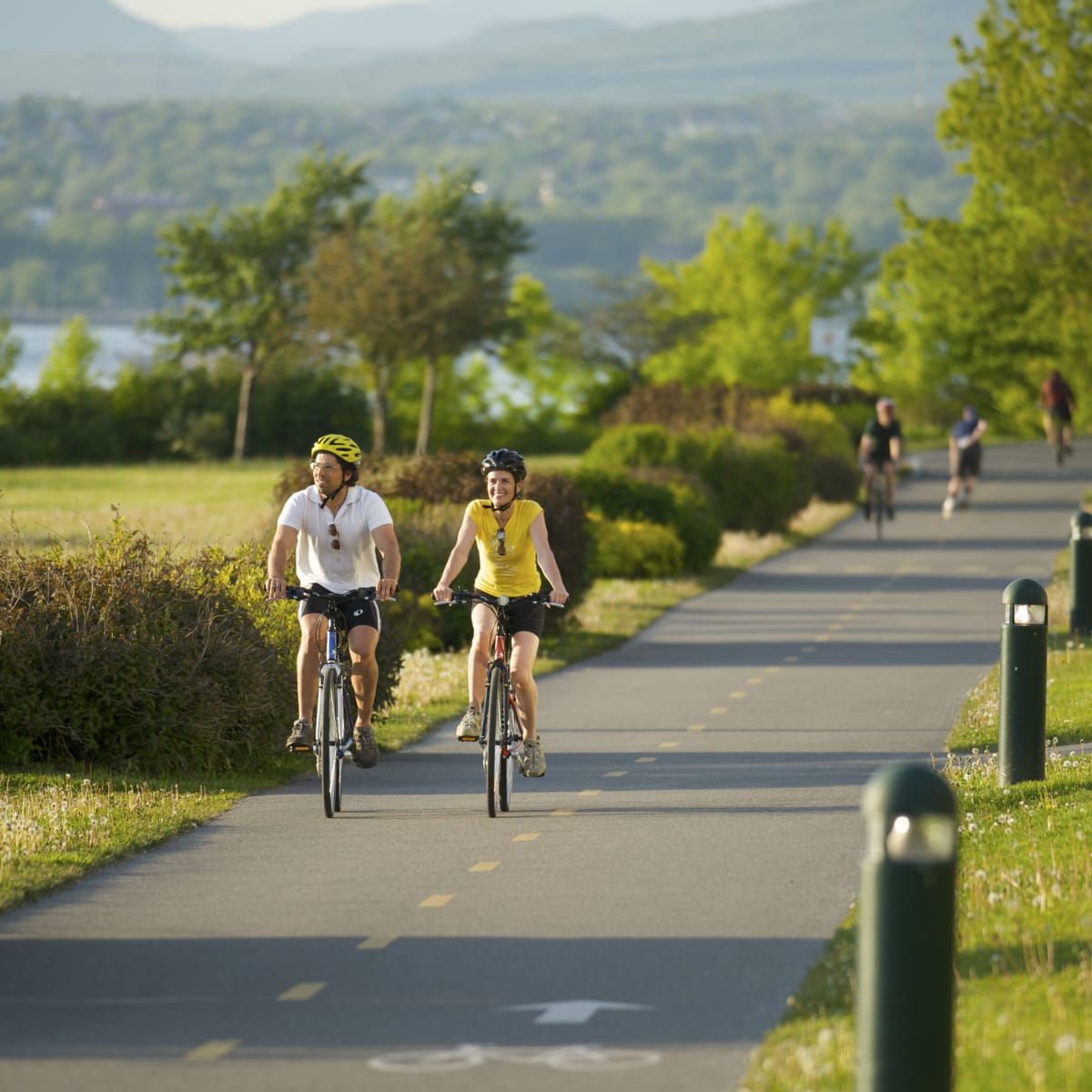 Couple à vélo sur une piste asphaltée - Parcours des Anses