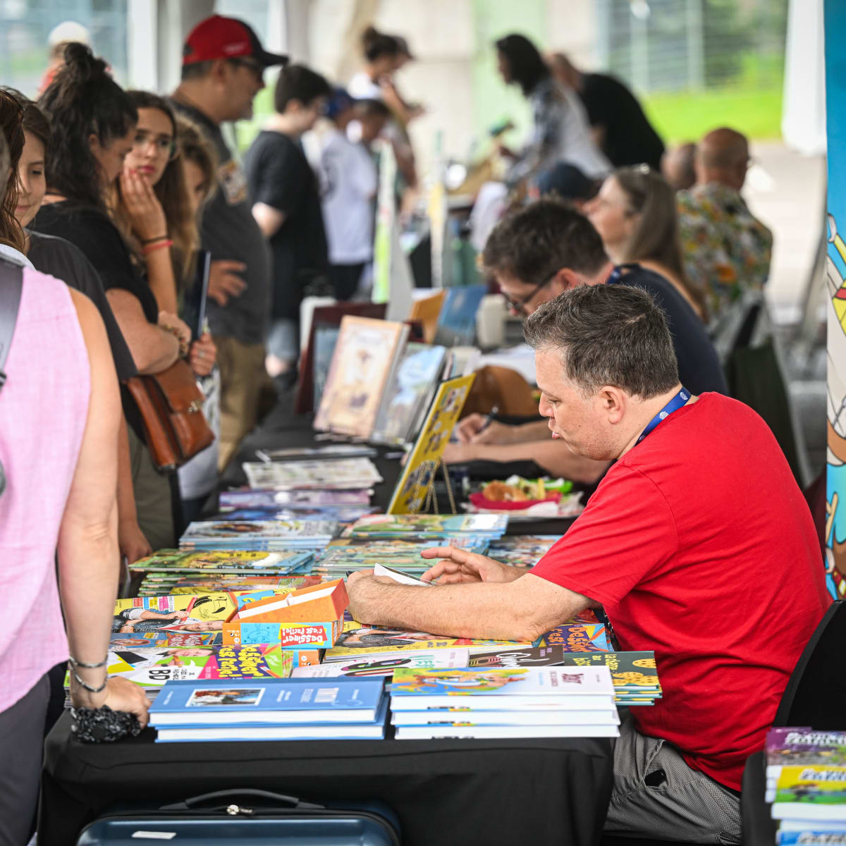 Festival de la BD de Prévost - Des bédéistes assis à des tables rencontrent des personnes
