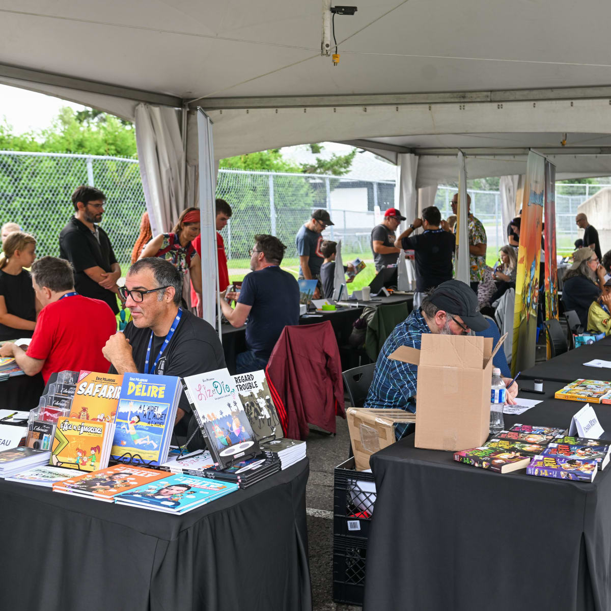 Festival de la BD de Prévost - Des bédéistes assis à des tables rencontrent des personnes