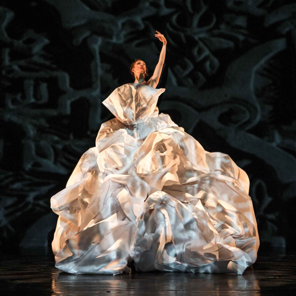 Festival des Arts de Saint-Sauveur - Une danseuse sur scène, vêtue d'une robe volumineuse et blanche qui ressemble à du papier froissé.