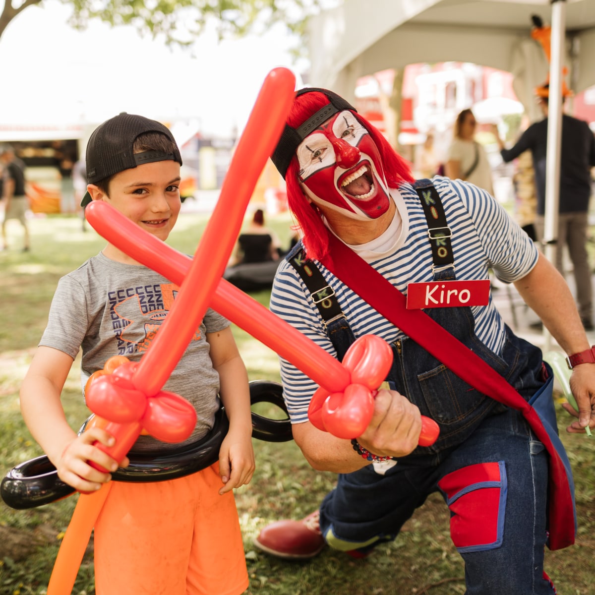 Young man and entertainer with sword-shaped balloons.