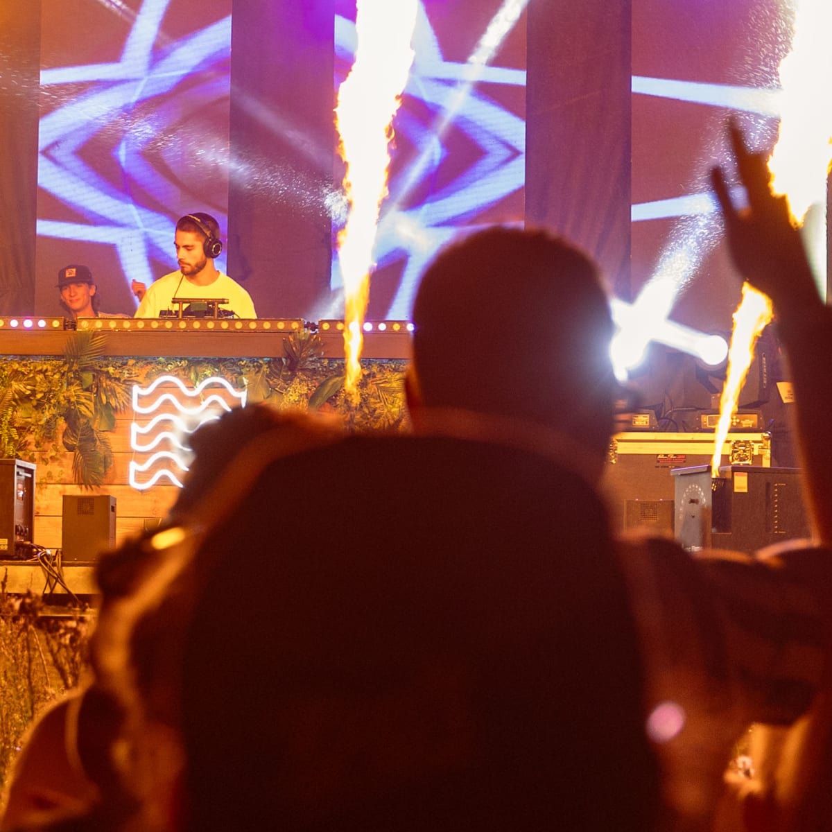 M DGTL - A DJ is on stage during the night, illuminated by flame projectors.