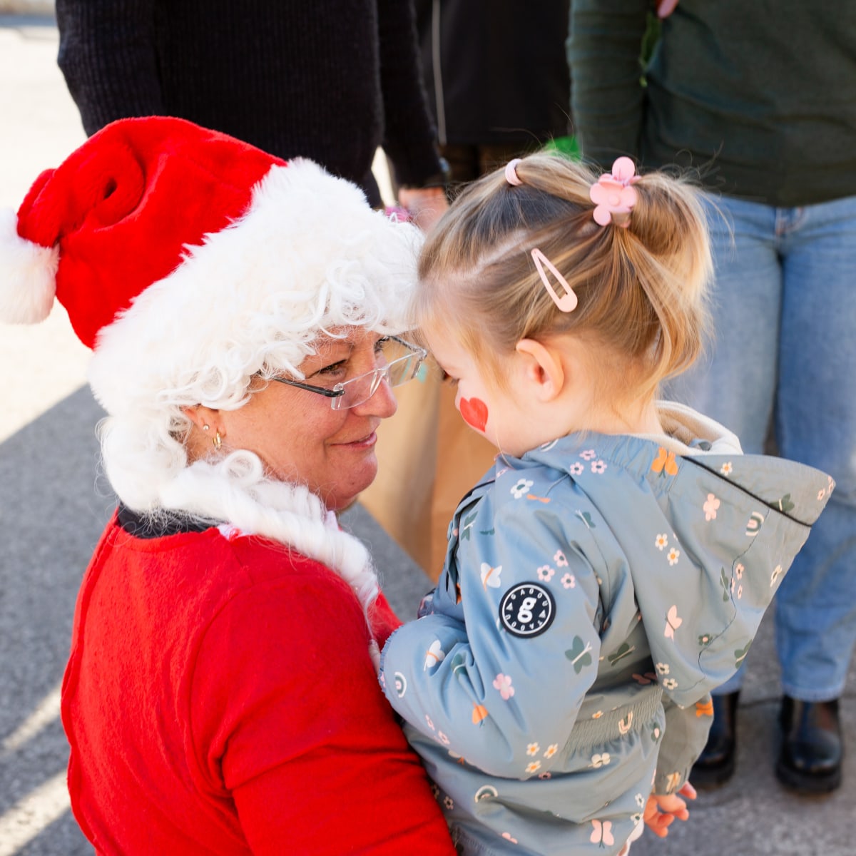 Marché de Noël de Prévost - Une femme déguisée en Mère Noël tient un enfant dans ses bras.