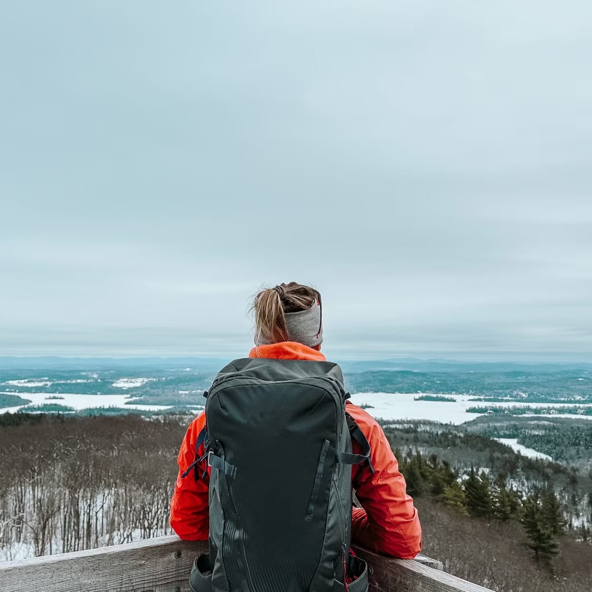 Discover Outaouais and its many areas with these must-sees! - Hiker admiring the view from a mountaintop in winter