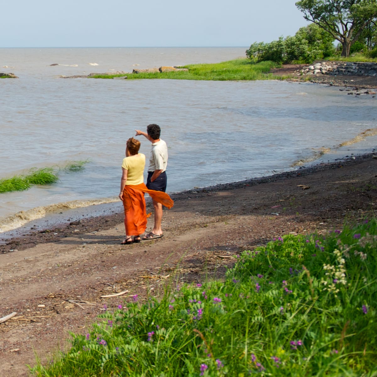 Couple by the water looking at the river.