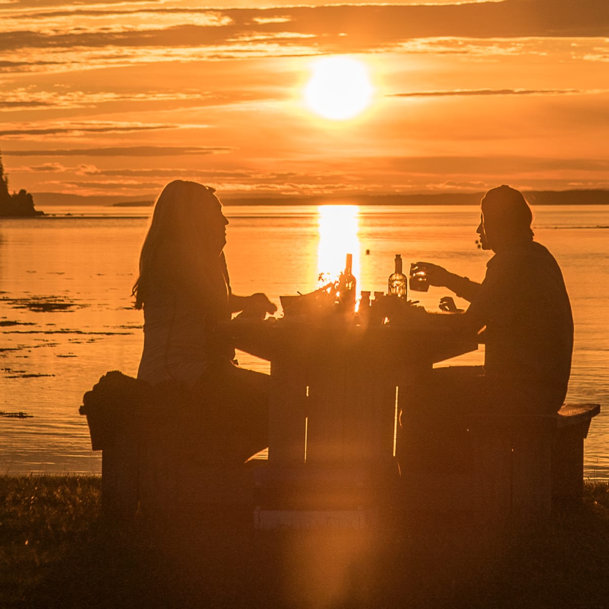 Couple having supper by the water.