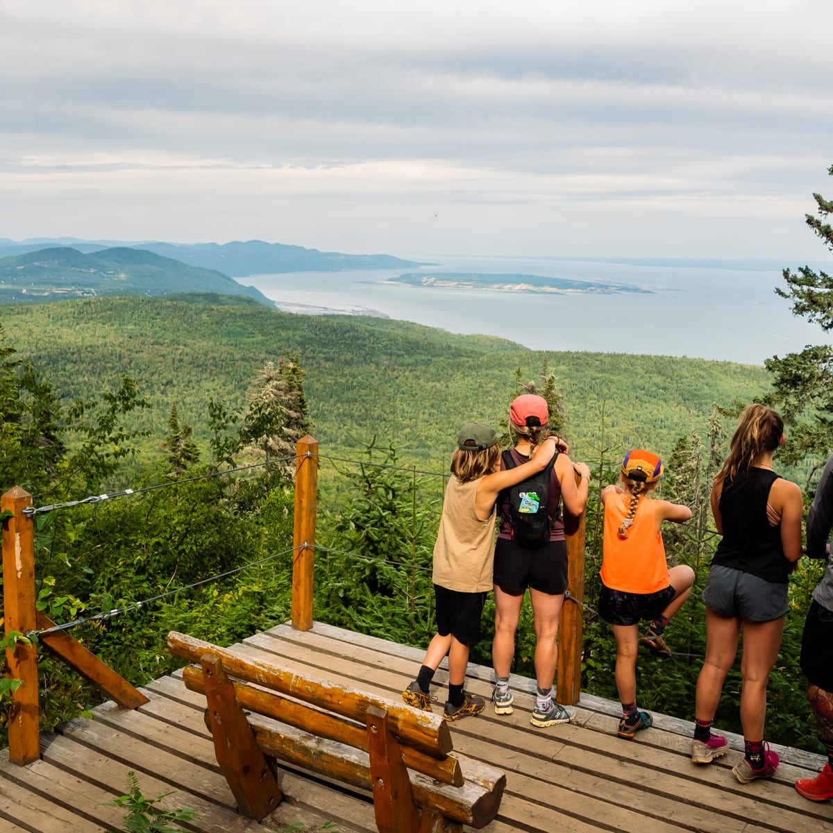 Family on a hike stopping at a lookout in Charlevoix.