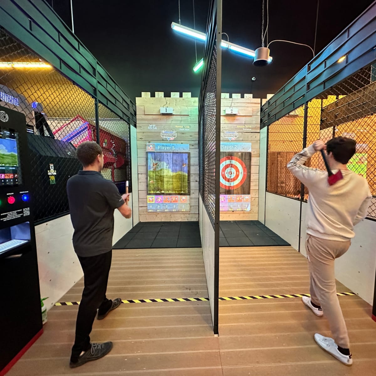 Two men taking part in an axe-throwing activity.