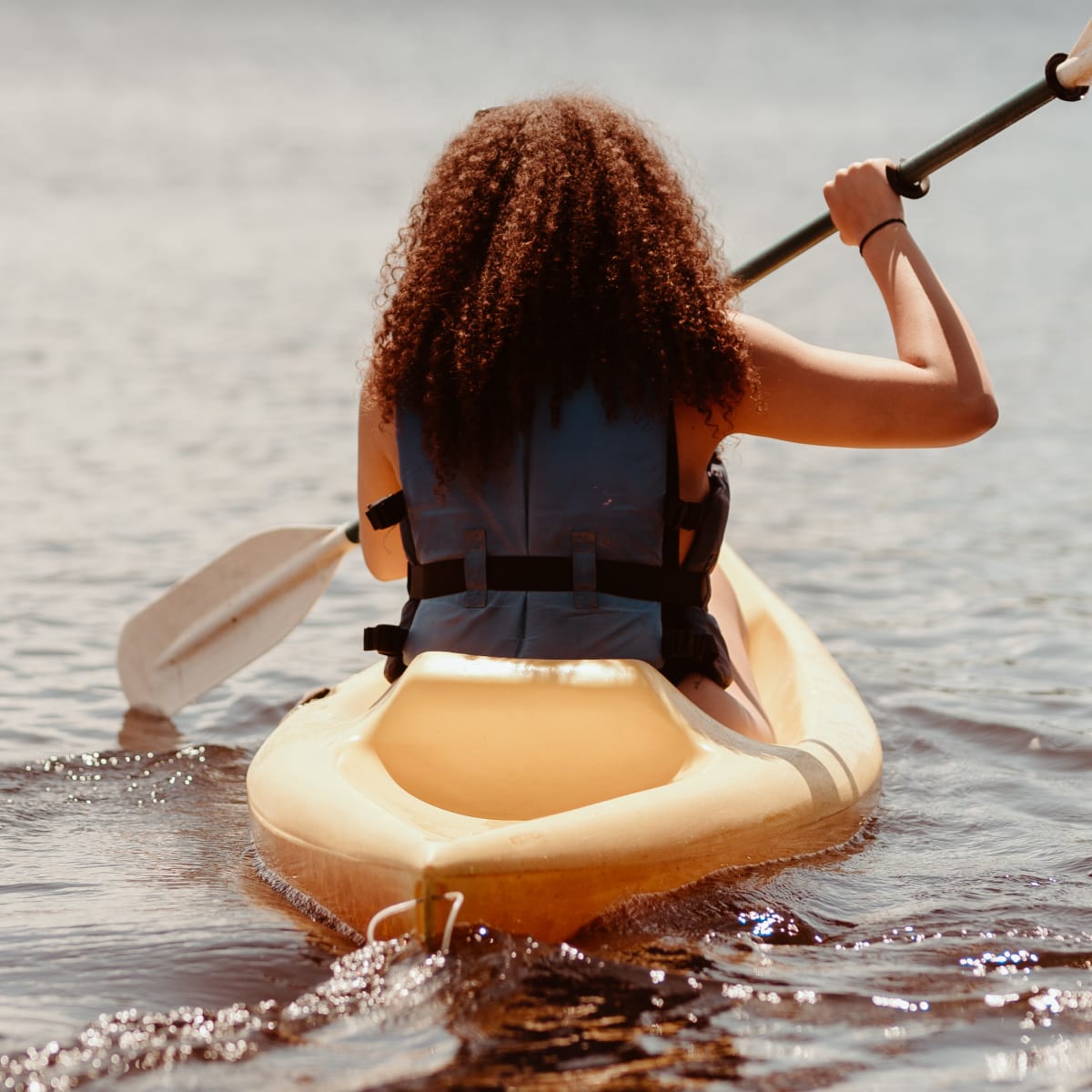 Jeune femme en kayak sur le lac. Young woman in a kayak on the lake.
