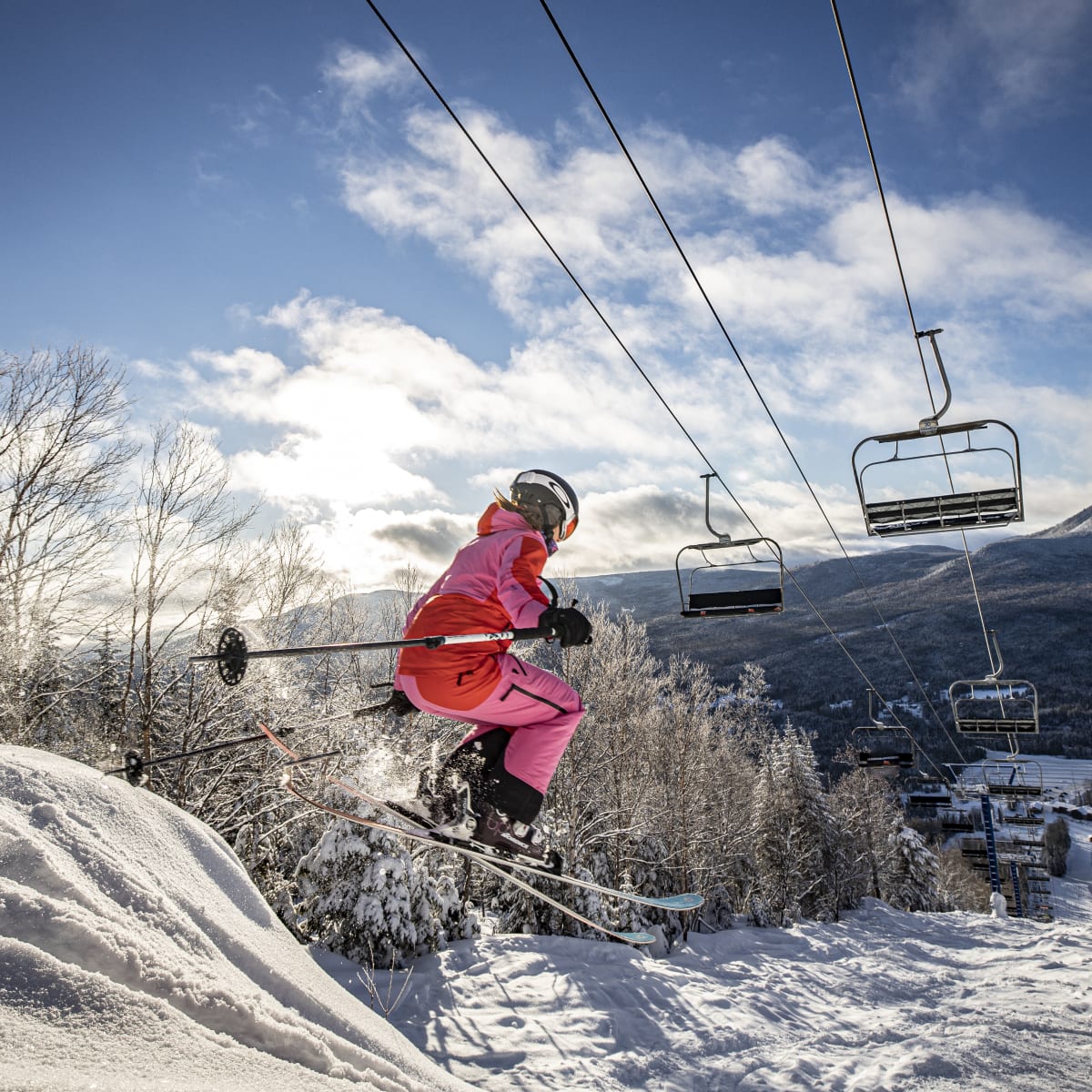 Skier making a jump underneath the ski lifts.