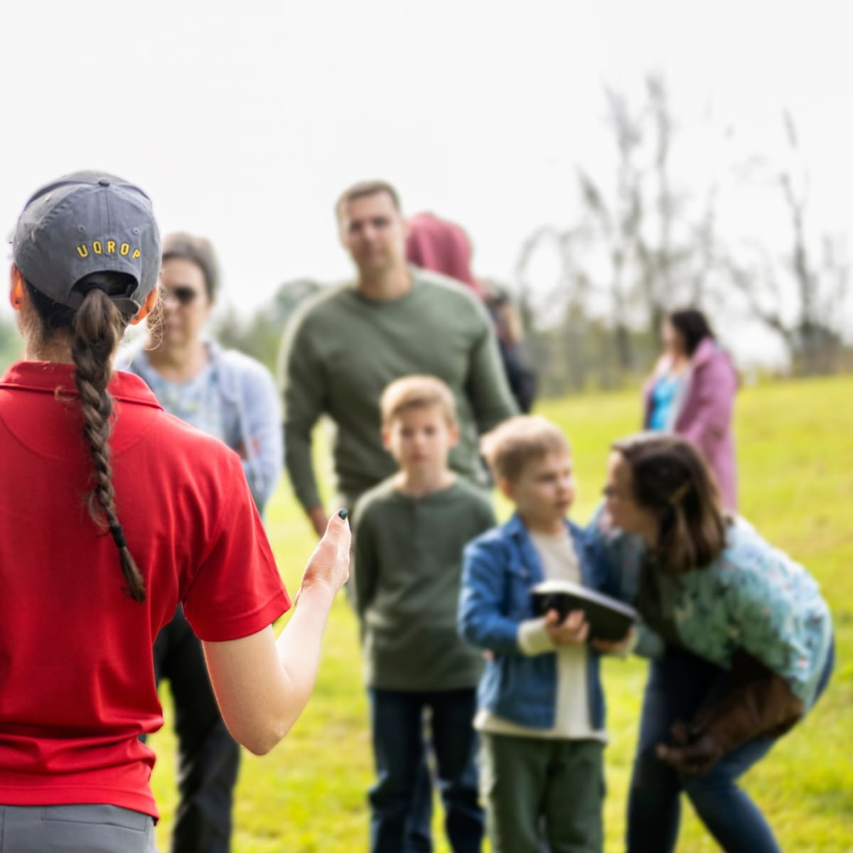 Guide qui fait une démonstration avec une chouette devant quelques personnes.