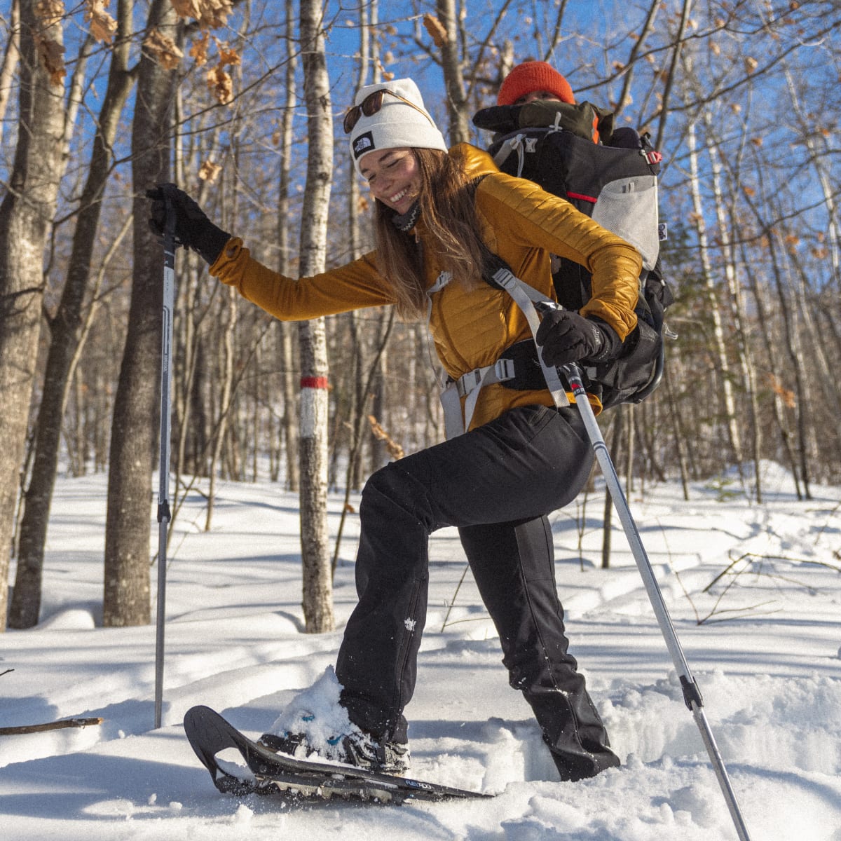 Young mother and baby on a snowshoeing trail