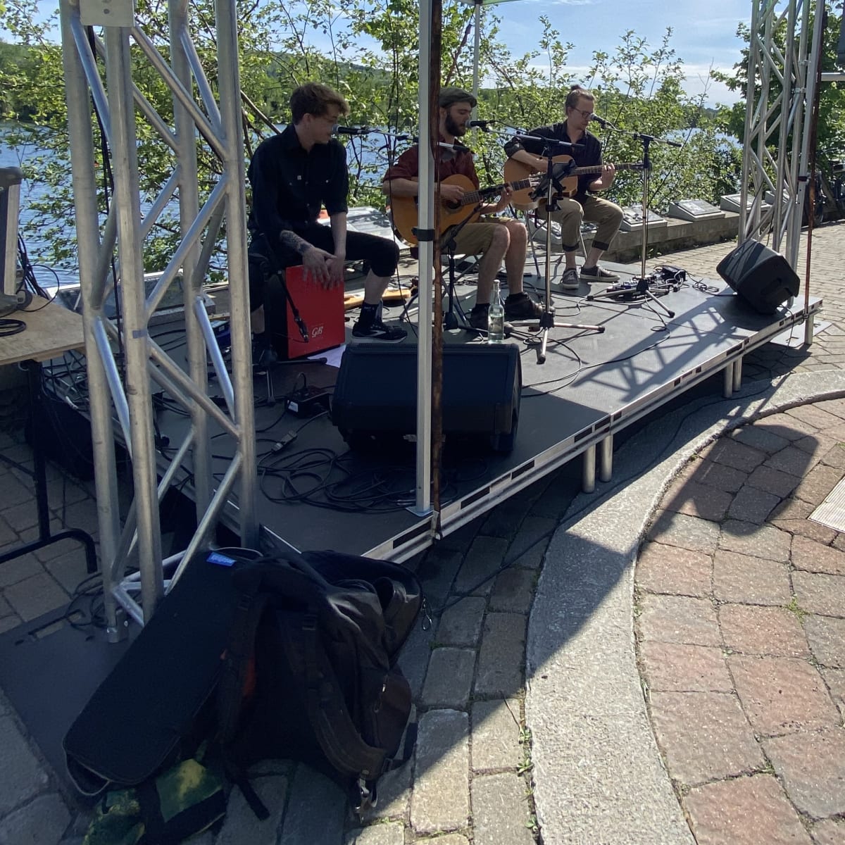 Sherbrooke en musique - Music group performs on an outdoor stage by the water.