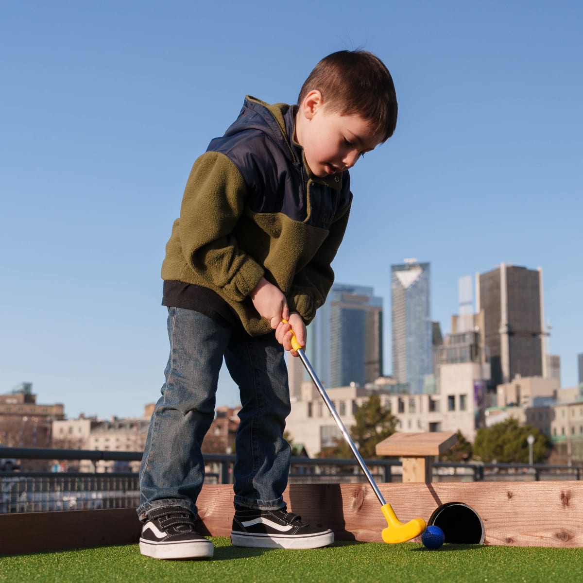 Young boy playing mini-putt