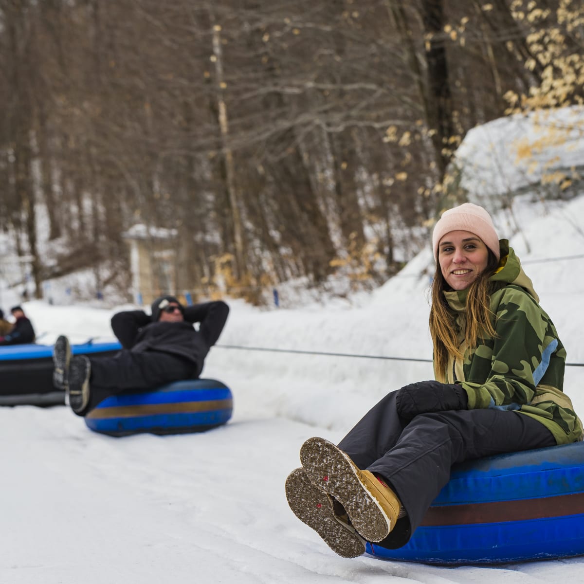 3 people on winter sliding tubes.