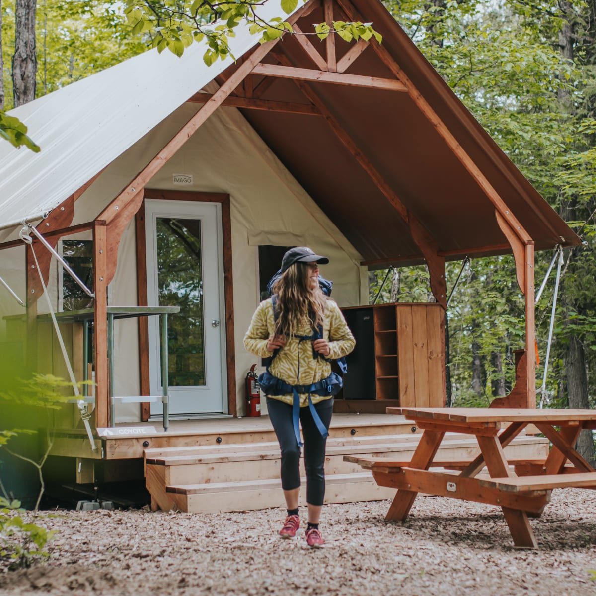 Woman in front of a ready-to-camp accommodation.
