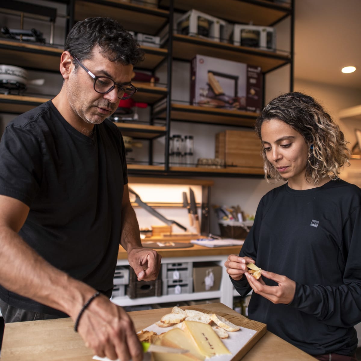 A man and a woman at a cheese tasting.