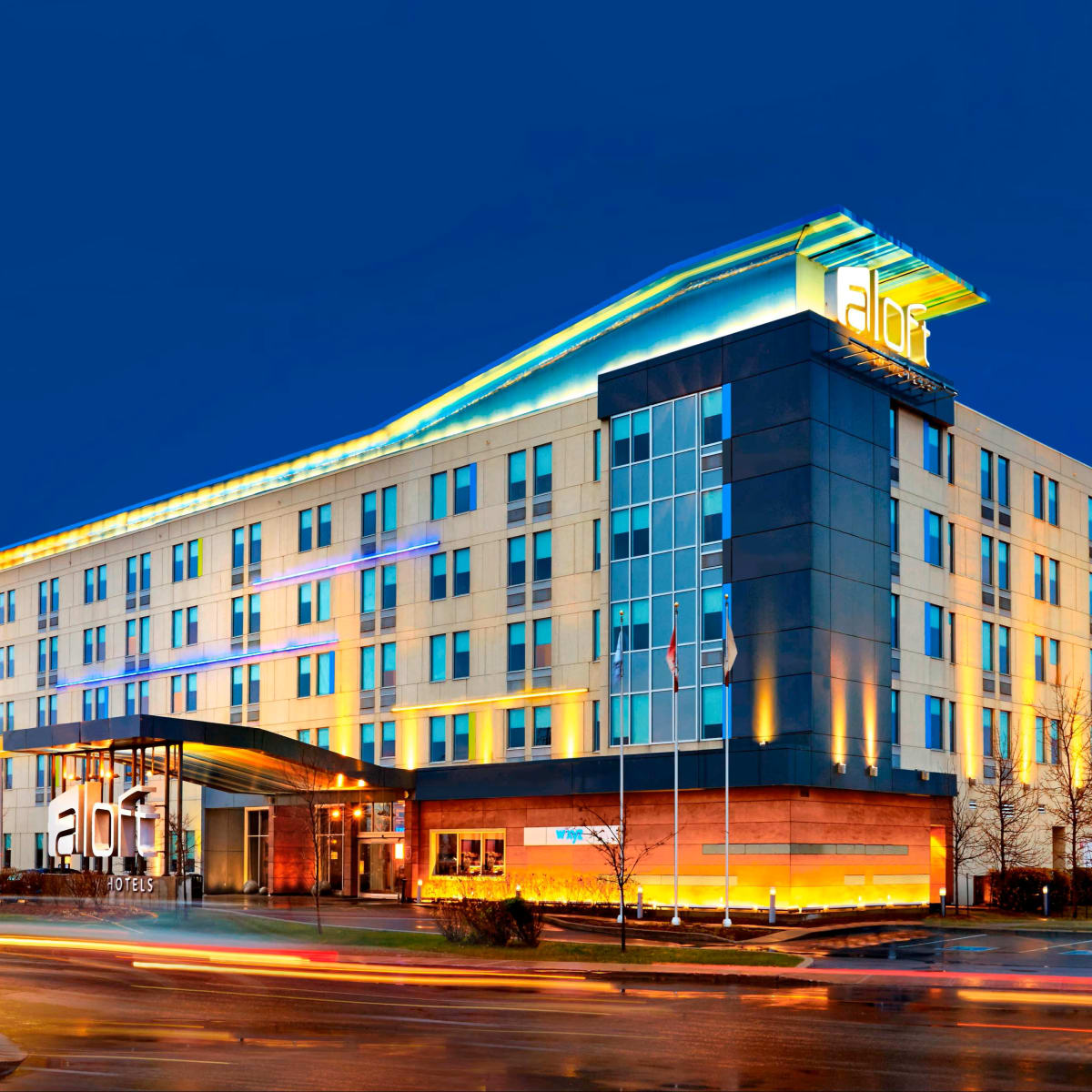 Aloft Montréal Airport - The hotel's illuminated exterior in the evening