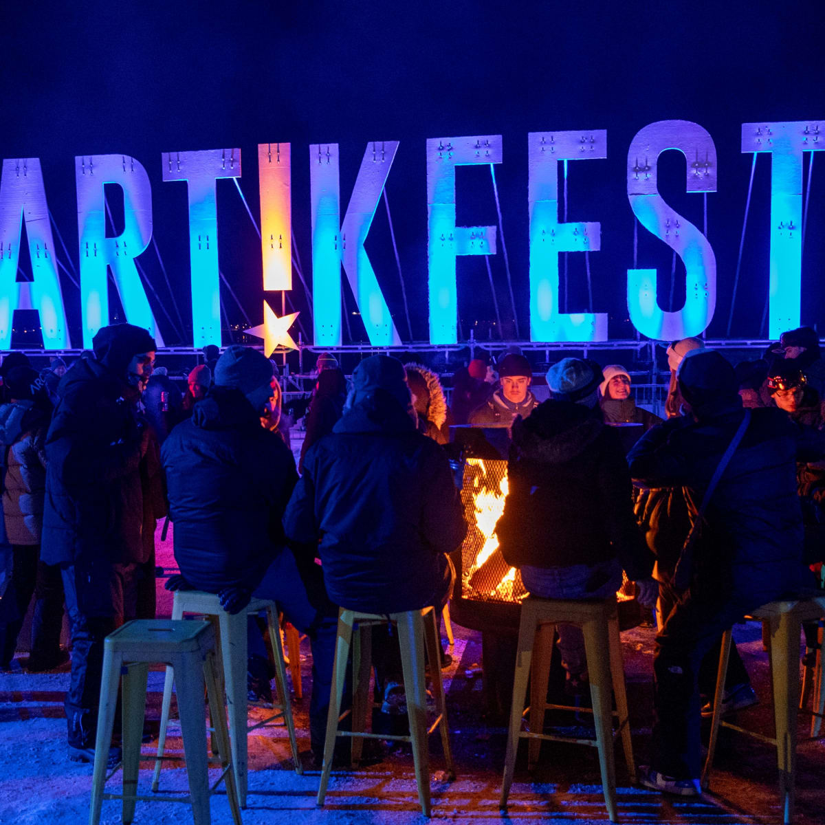 People sitting around a fire at ArtikFest.