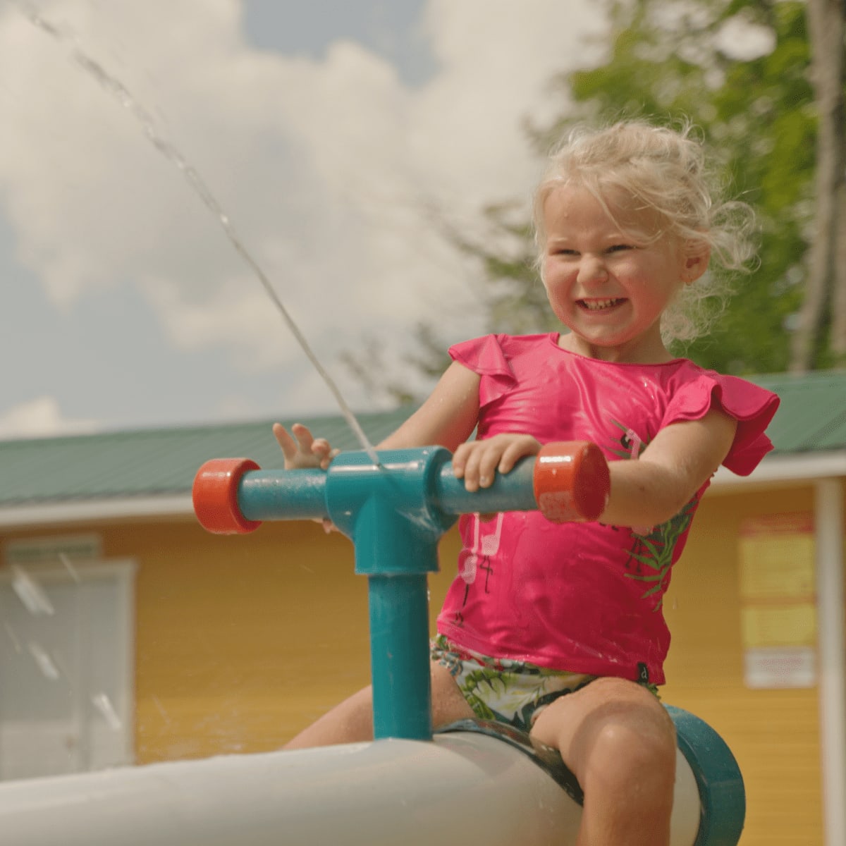 Child playing with water at Au Pays des Merveilles.