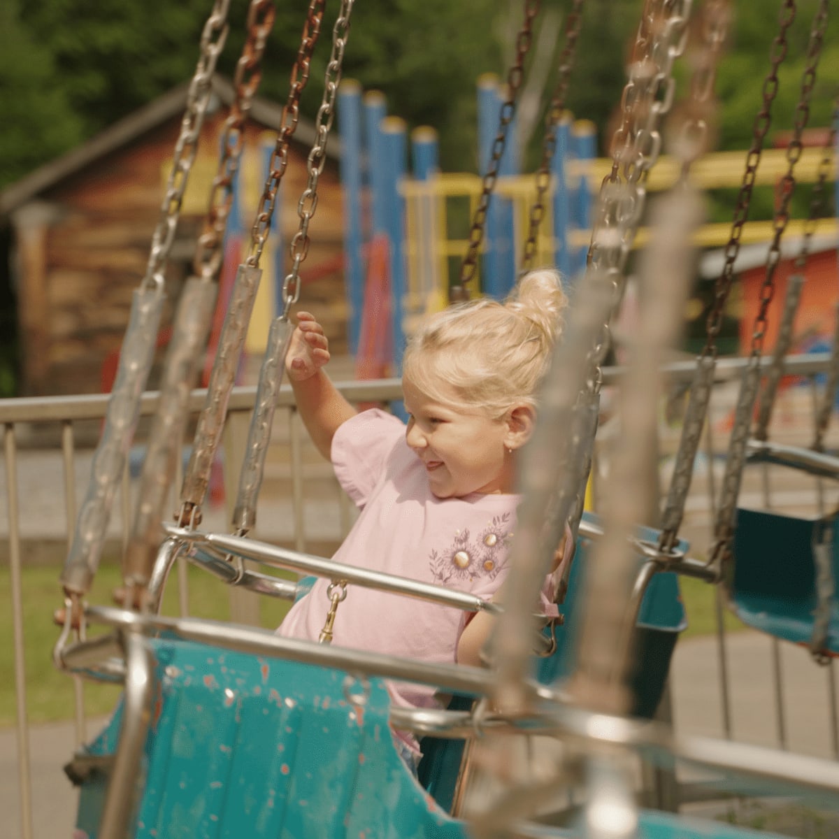Girl in a flying chair at Au Pays des Merveilles.