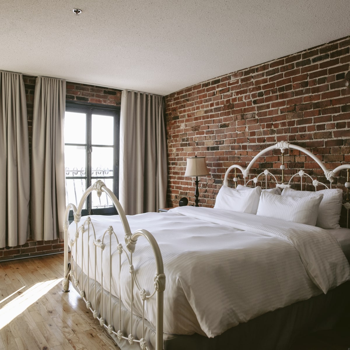 Auberge du Vieux-Port - Chambre avec un mur de briques