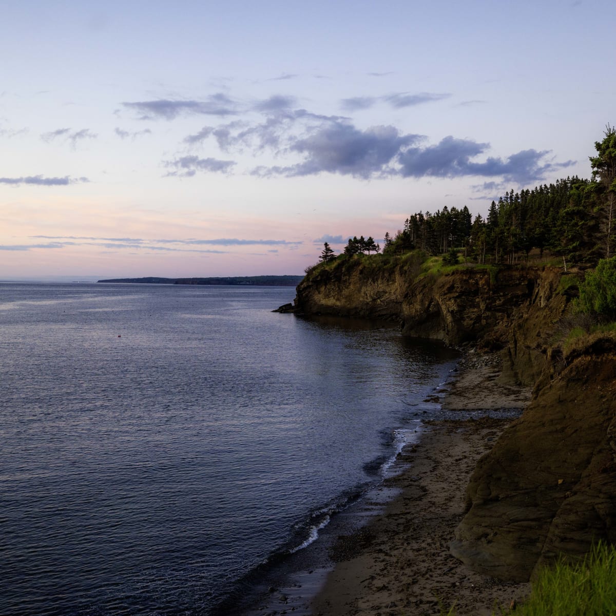 Steep cliffs in the Gaspé Peninsula at sunset.