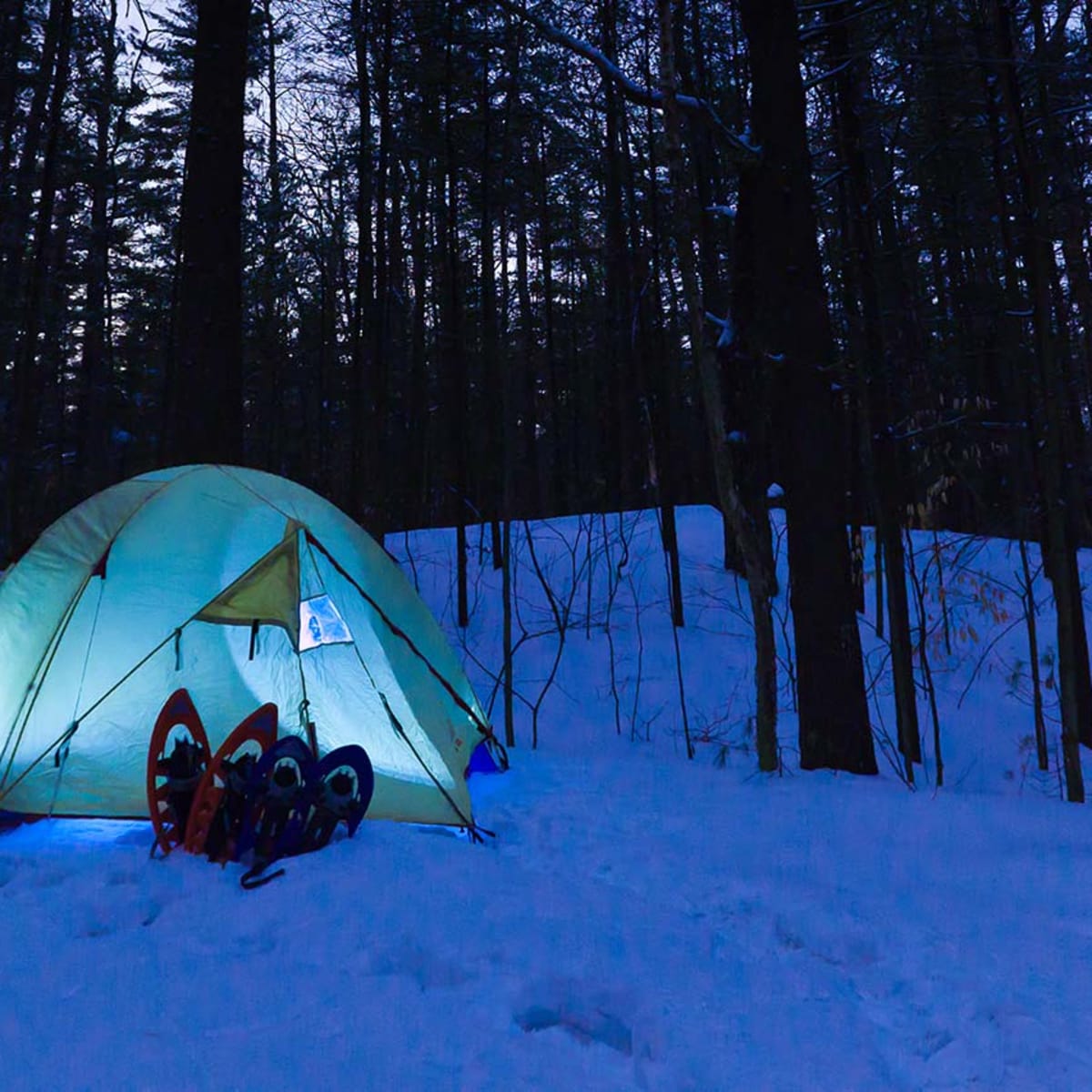 Une tente illuminée en hiver au Camping du parc national d'Oka.