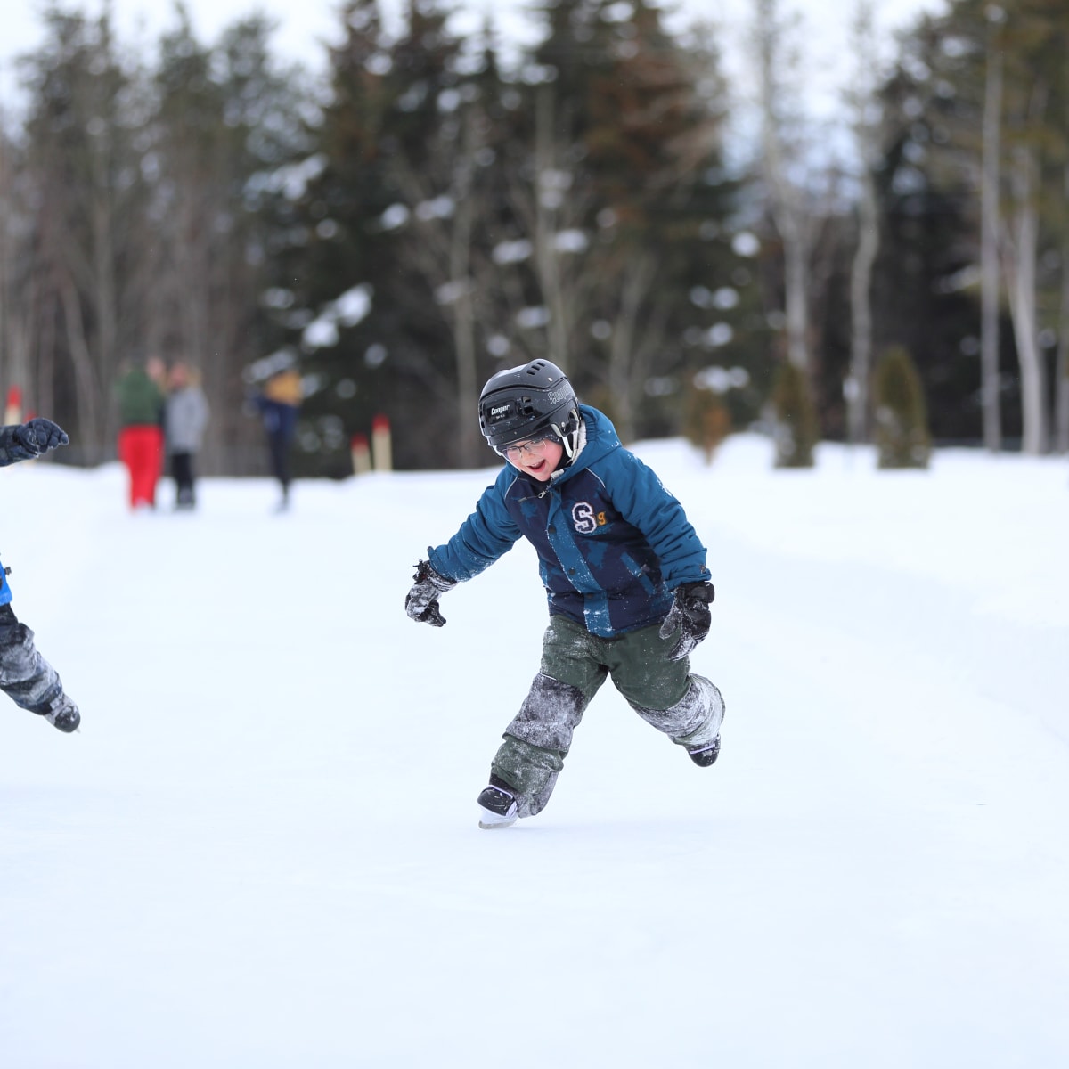 Two children are skating at the Dam-en-Terre Resort.
