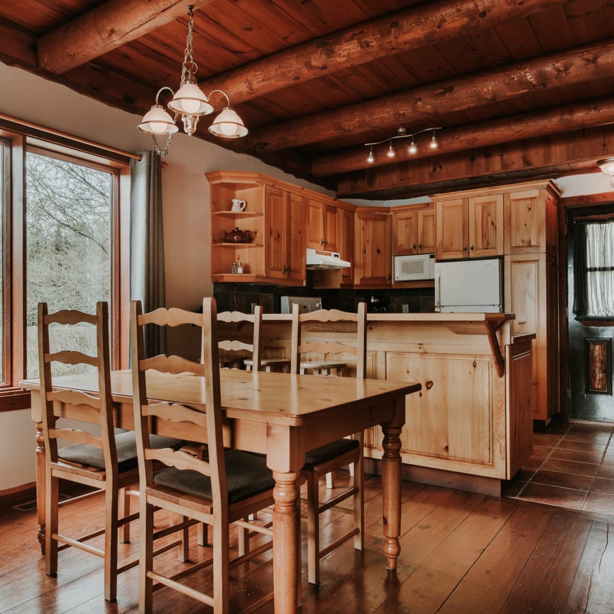 Kitchen and dining room with seating for four in one of the Chalets Royal Laurentien.
