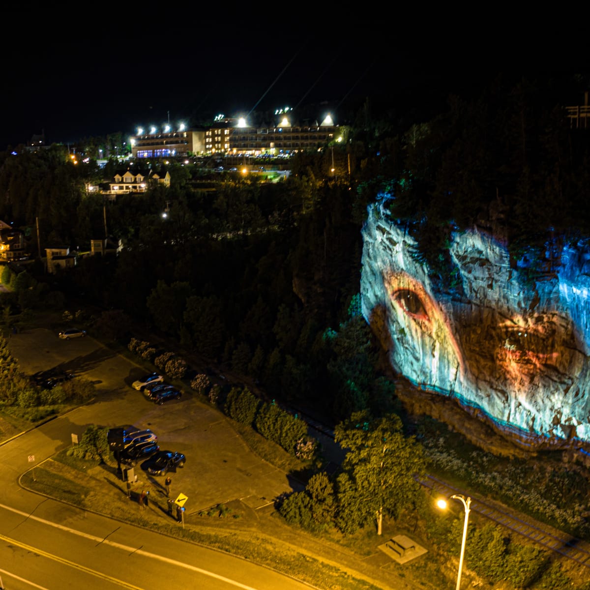 Cité Mémoire - Light projection of a human gaze on a rock wall at night