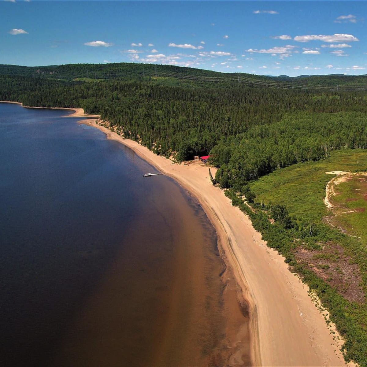 Aerial view of the outfitter's natural landscapes, featuring a sandy beach.
