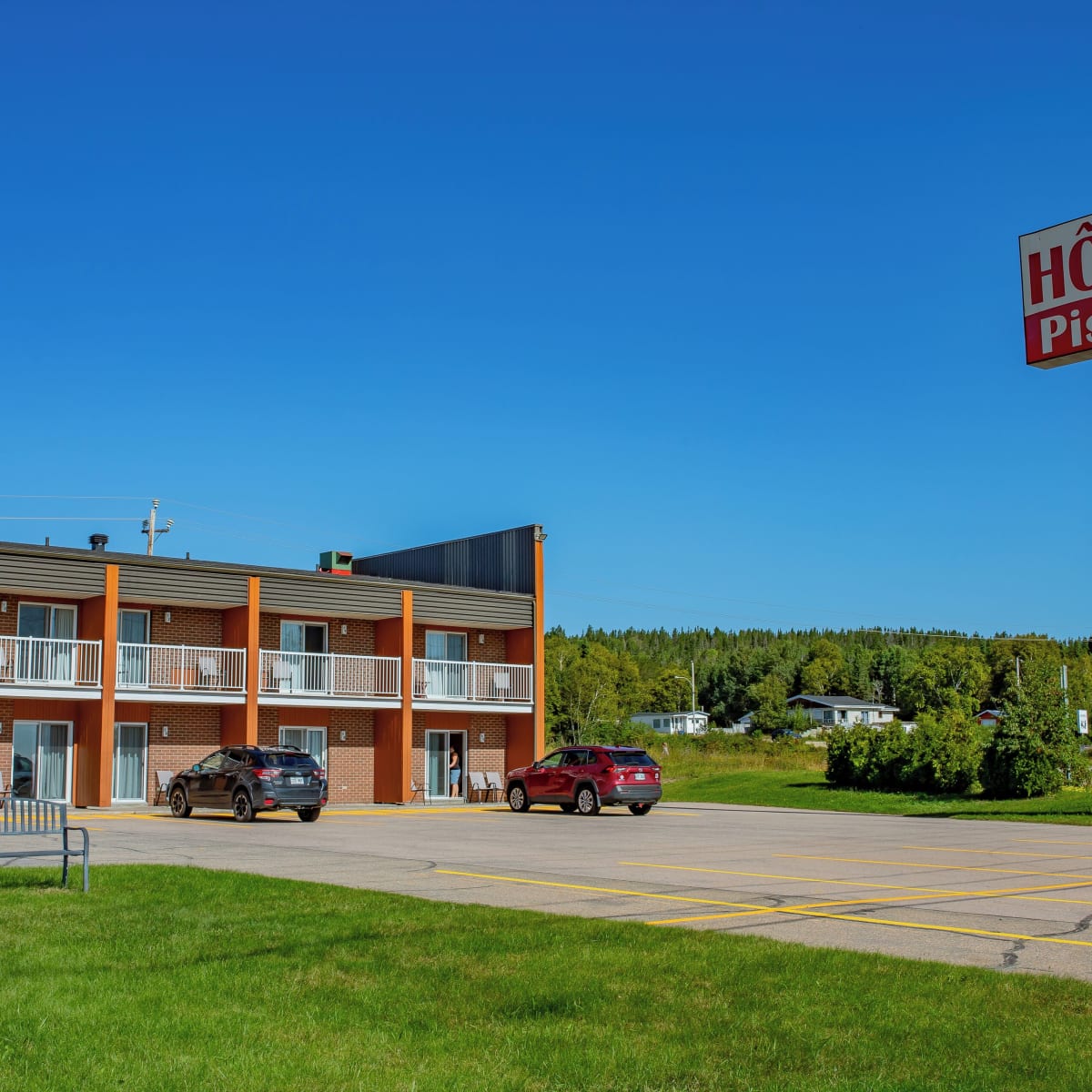 Exterior of the Complexe Hôtelier Escoumins in summer.