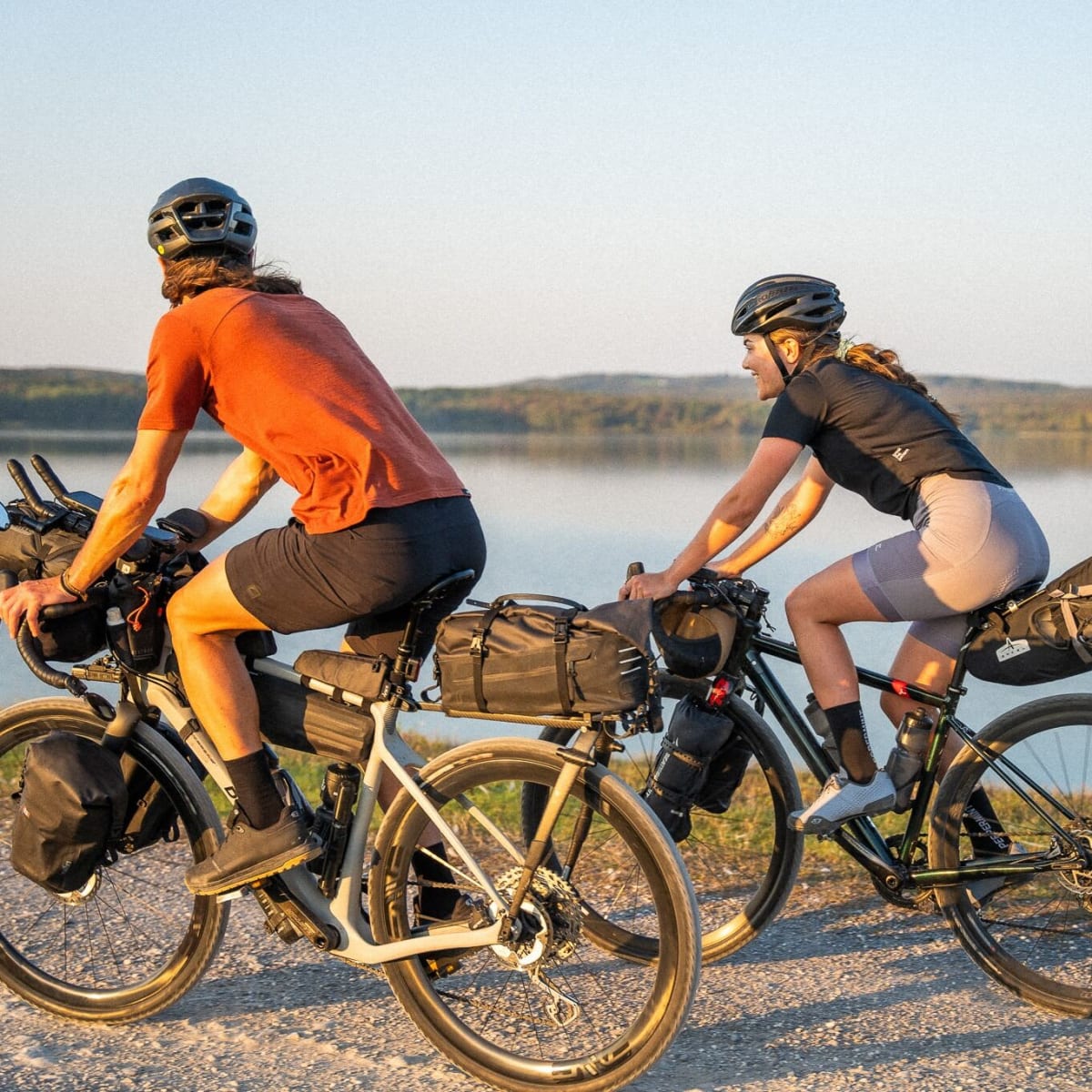 A man and a woman on their bicycles, equipped with luggage.