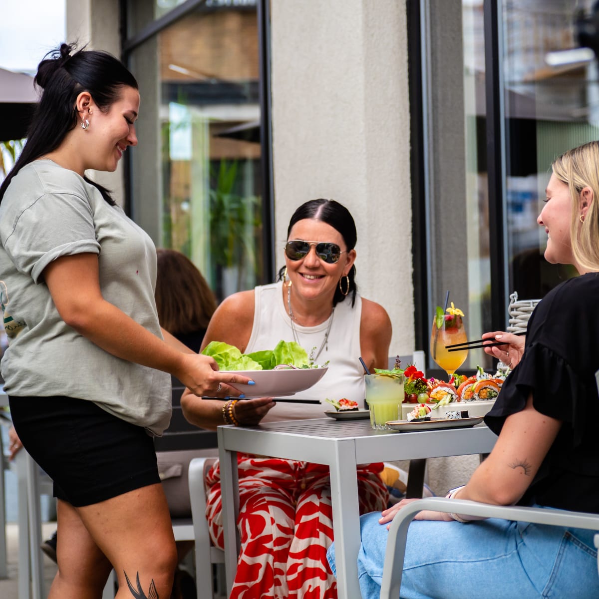 Destination Salaberry-de-Valleyfield - A waitress brings a dish to a table where two women are seated.