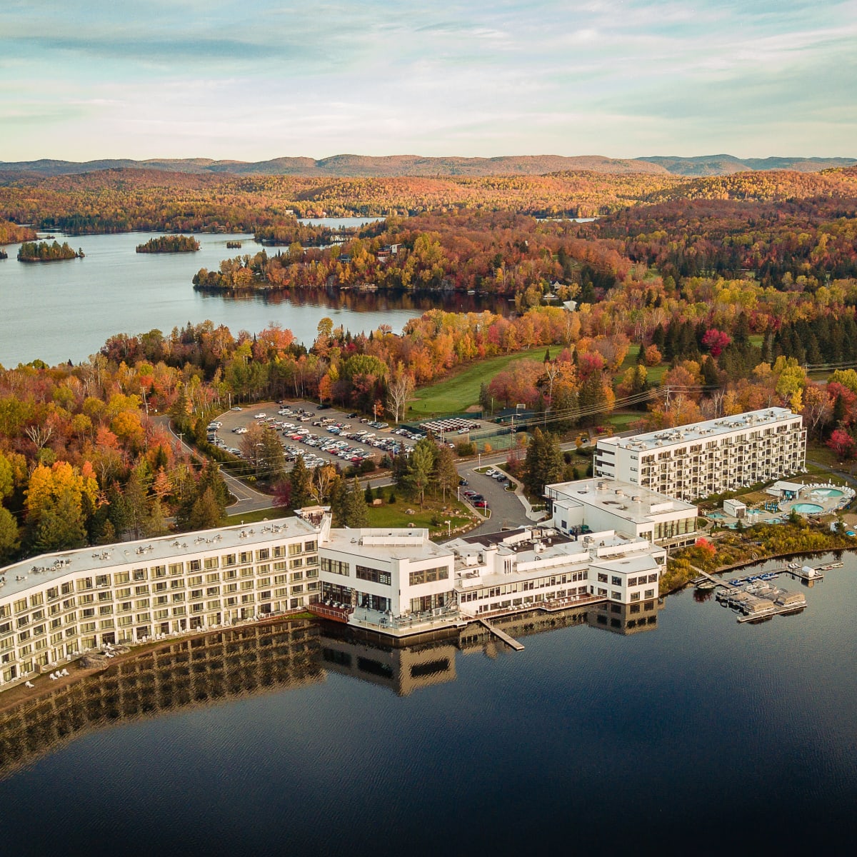 Plan aérien de l'Estérel Resort, entouré d'un lac et de forêts colorées.