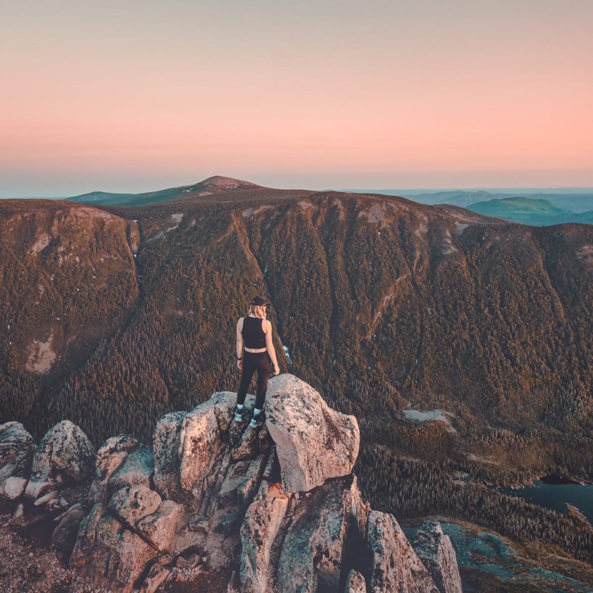 A hiker at the summit of a mountain in Parc national de la Gaspésie.