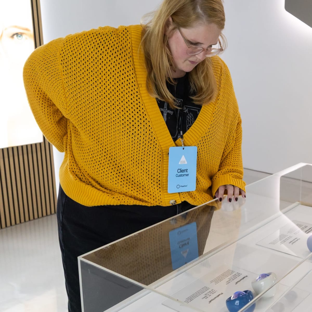 Femme en train de regarder un présentoir à la boutique du géant technologique fictif Laboratoire Phaeton.