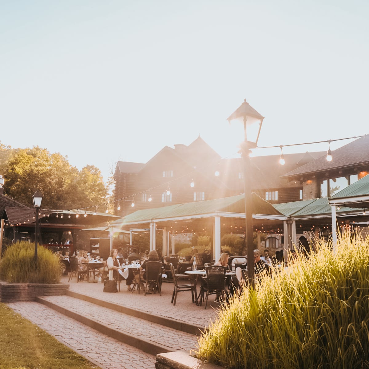 Outdoor terrace of the Aux Chantignoles restaurant bathed in golden light
