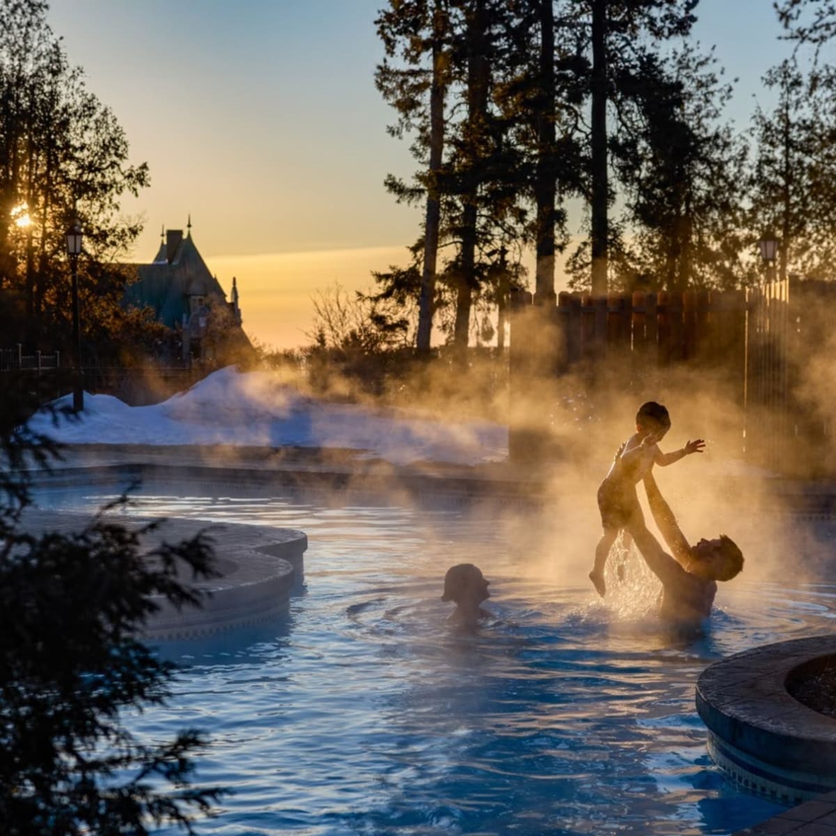 Family swimming in the outdoor pool in winter at Fairmont Le Manoir Richelieu.