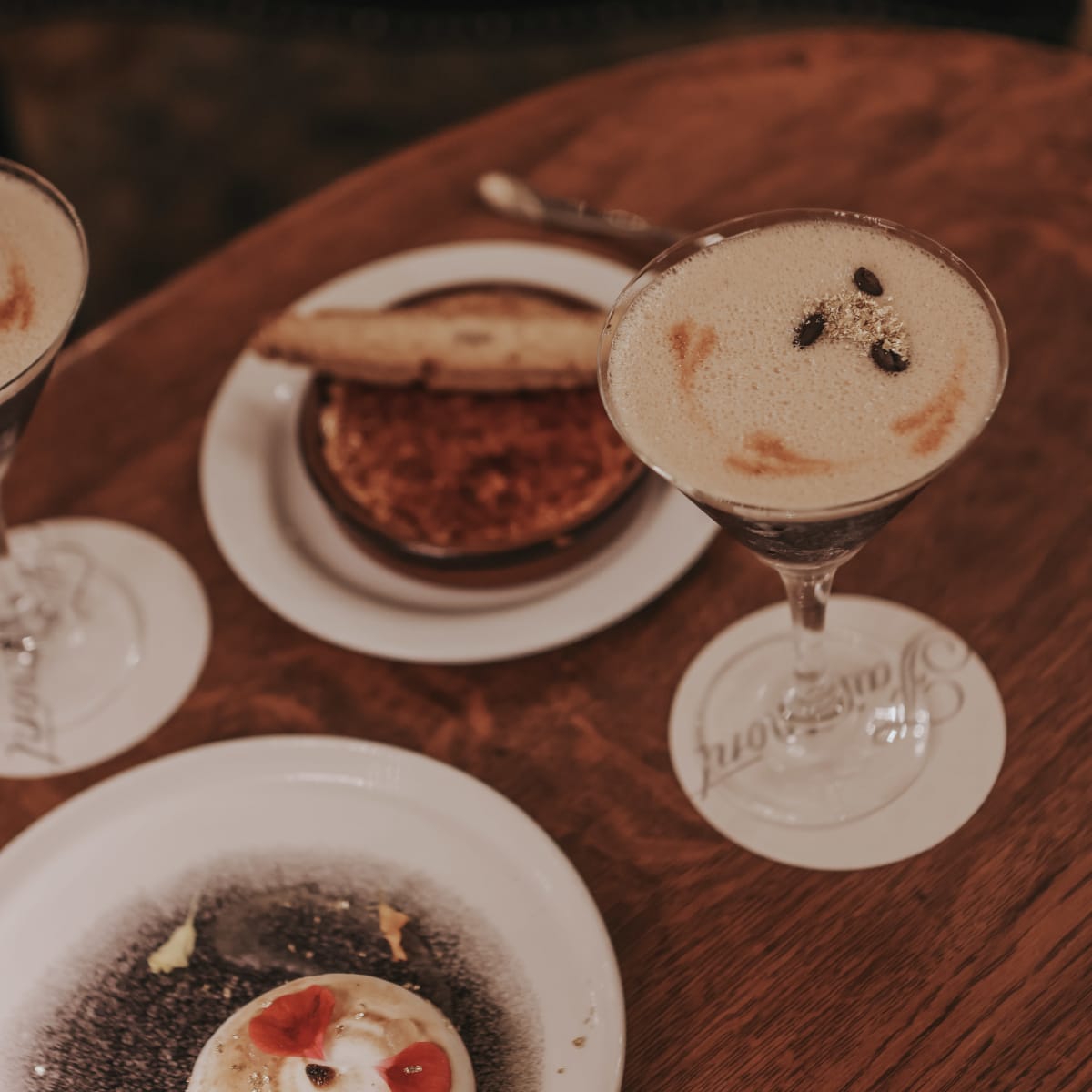 A table with cocktails and beautifully presented desserts.