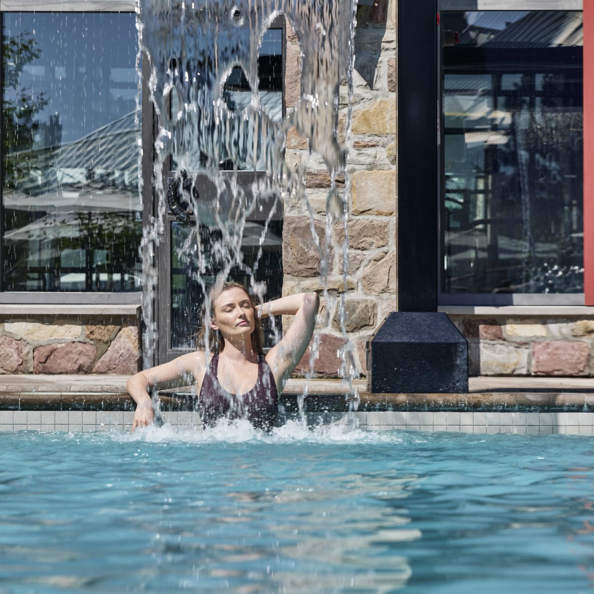 Femme dans la piscine extérieure du Fairmont Tremblant.