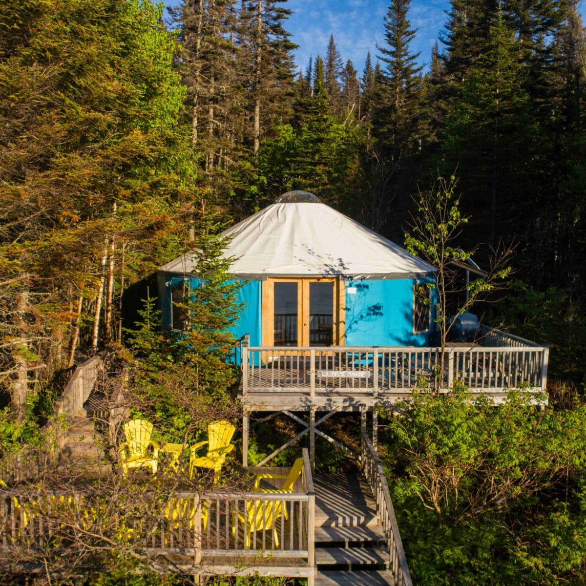 Blue yurt by the water in summer.