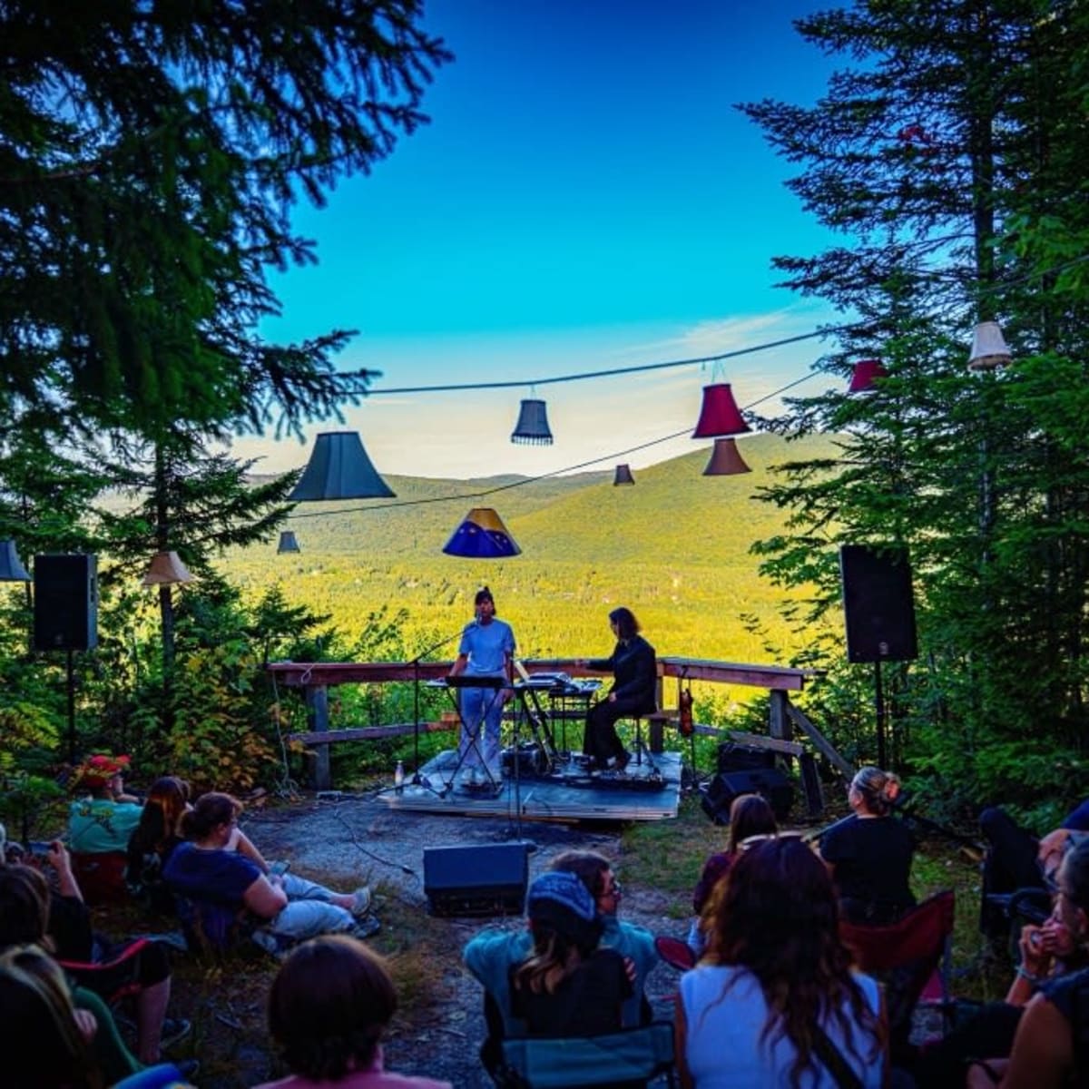 Concert au belvédère : public assis, abat-jours et vue sur la vallée