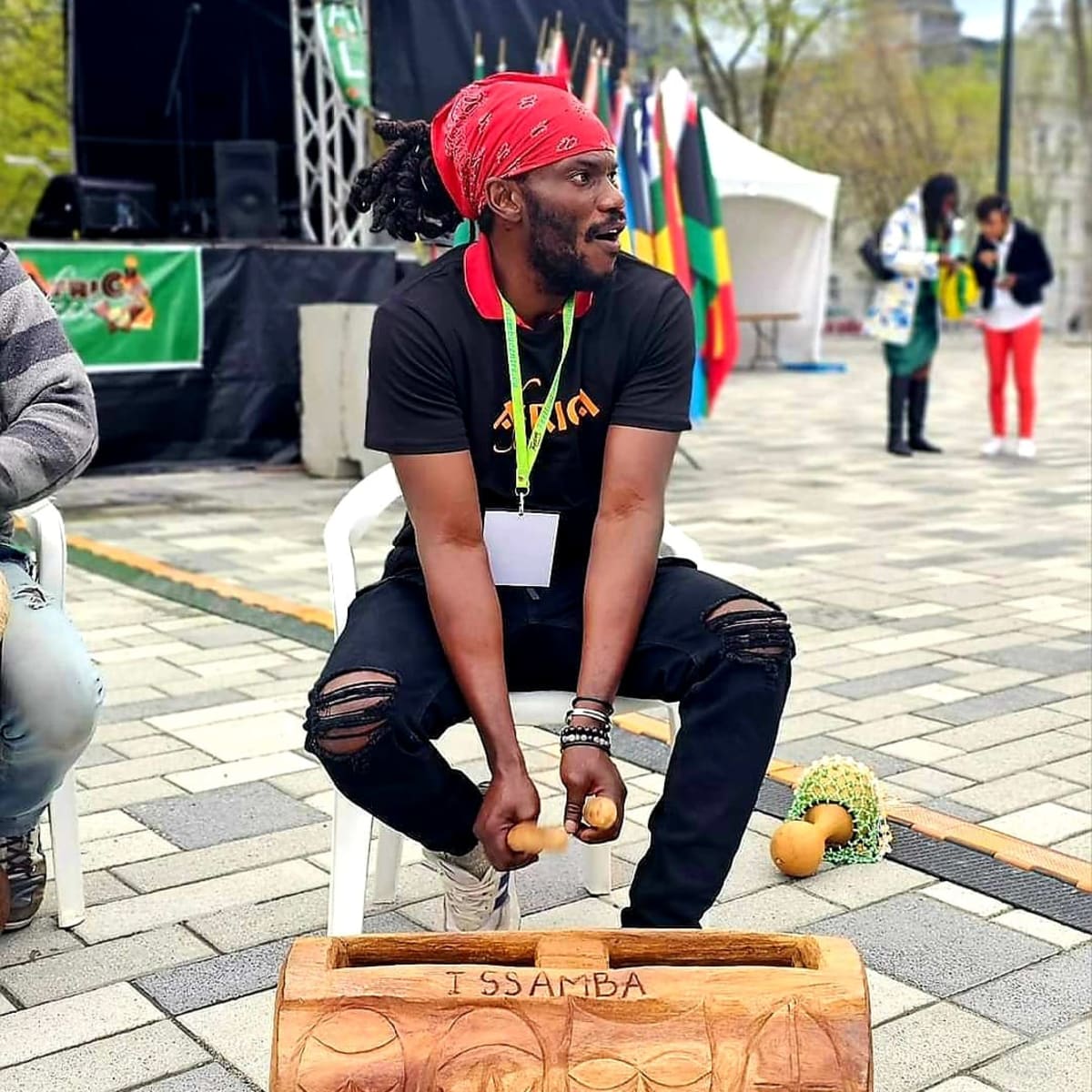 Festival AfriCa Fest - Un homme est assis et joue d'un instrument.